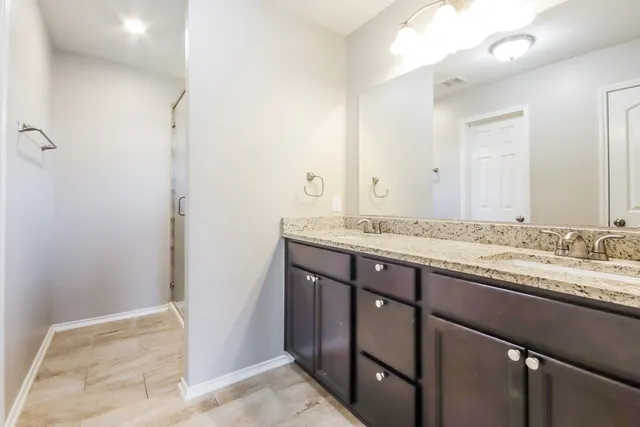 a bathroom with a granite countertop sink and a mirror