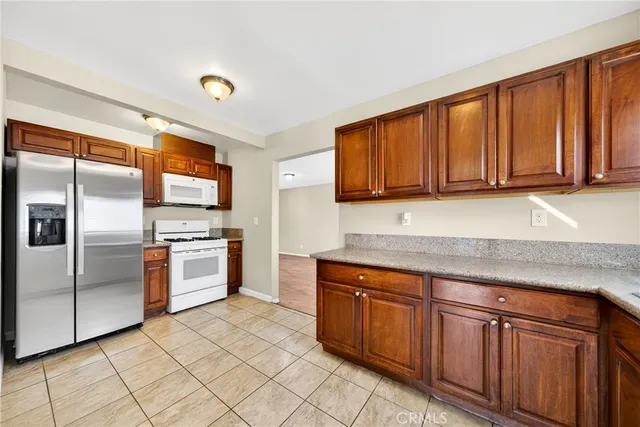 a kitchen with stainless steel appliances granite countertop a refrigerator sink and cabinets