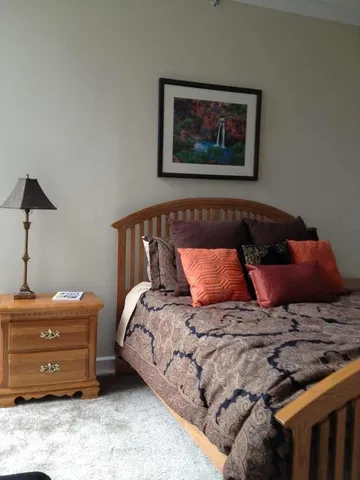 a bedroom with a bed and a painting on the wall