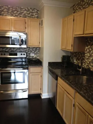 a kitchen with stainless steel appliances granite countertop a stove and a microwave