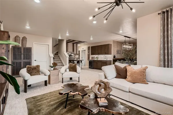 a living room with furniture a chandelier and a flat screen tv