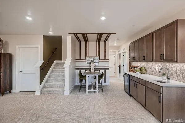 a kitchen with kitchen island granite countertop a sink cabinets and stainless steel appliances
