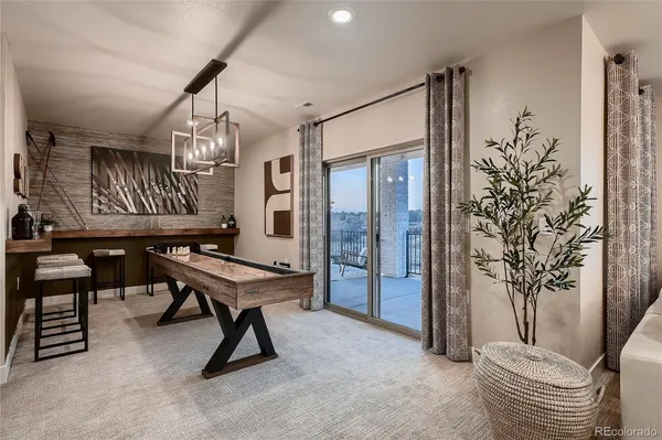 a room with chandelier fan and windows