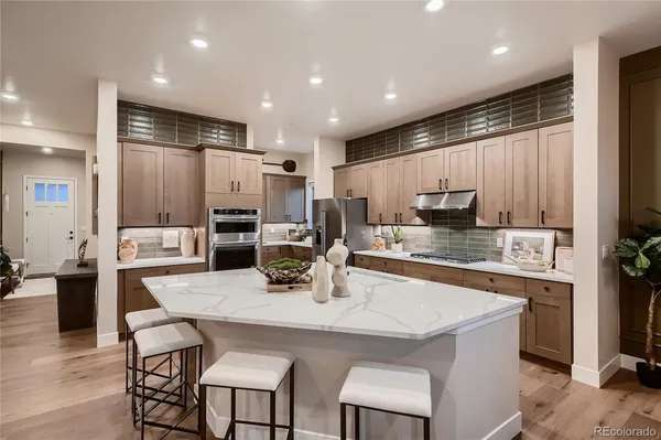 a kitchen with stainless steel appliances granite countertop a kitchen island a stove a table and chairs