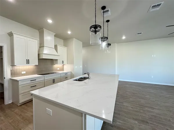 a kitchen with a sink a stove a refrigerator and white cabinets
