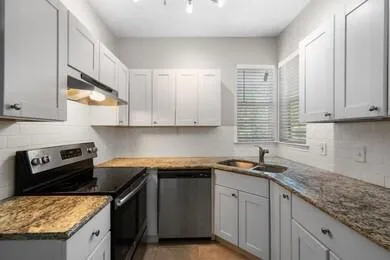 a kitchen with stainless steel appliances granite countertop a sink stove and cabinets
