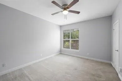 an empty room with a window and a fan