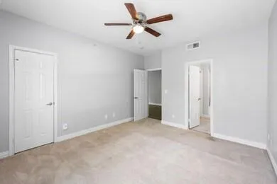 a view of an empty room and a ceiling fan