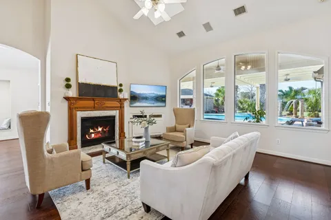 a living room with furniture fireplace and a large window