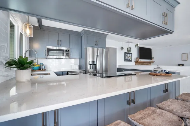 a kitchen with stainless steel appliances a sink a refrigerator a stove and cabinets