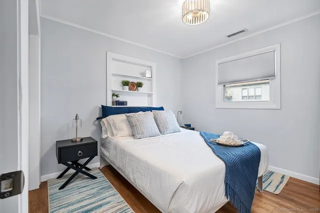 a bedroom with a bed and wooden floor