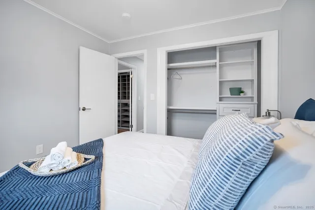 a bedroom with a bed and a dresser with wooden floor