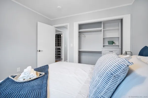 a bedroom with a bed and a dresser with wooden floor