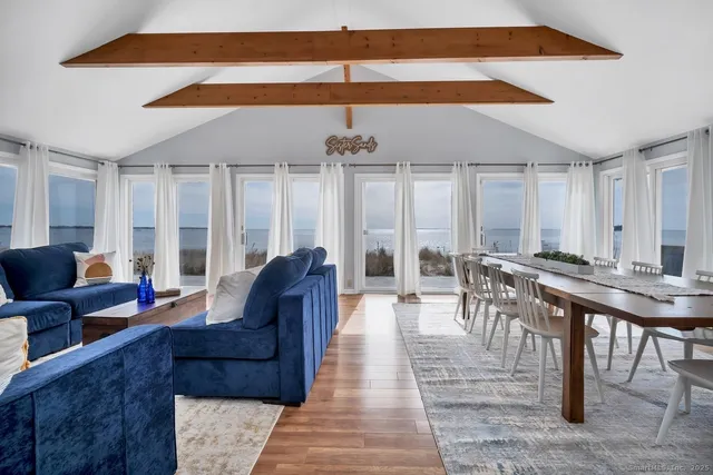 a living room with furniture a chandelier and a dining table