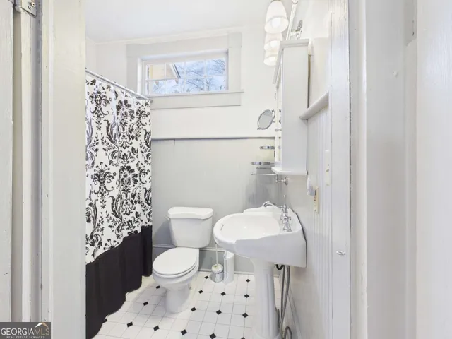 a bathroom with a toilet a sink and a shower