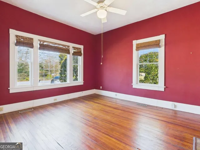 a view of an empty room window and wooden floor