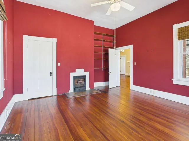 a view of an empty room with wooden floor