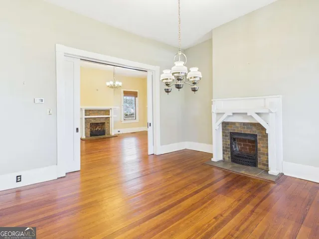 wooden floor fireplace and windows in an empty room