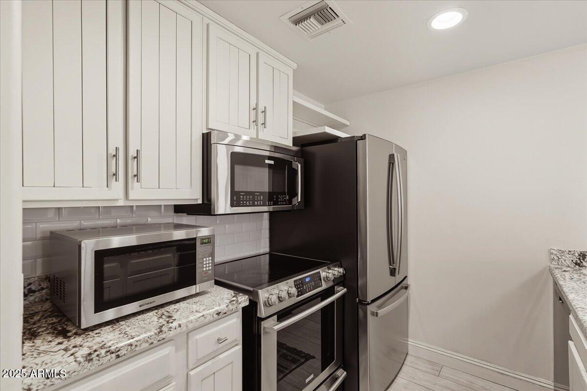 36601 North Mule Train Road, Unit B20 Carefree, AZ 85377 - Photo 11 of 27 a kitchen with stainless steel appliances white cabinets and a stove top oven
