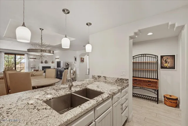 a kitchen with a chandelier a sink and a living room view