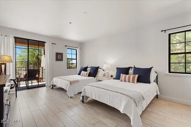 a spacious bedroom with two beds and large window