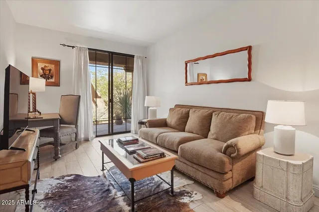 a living room with furniture a flat screen tv and a window
