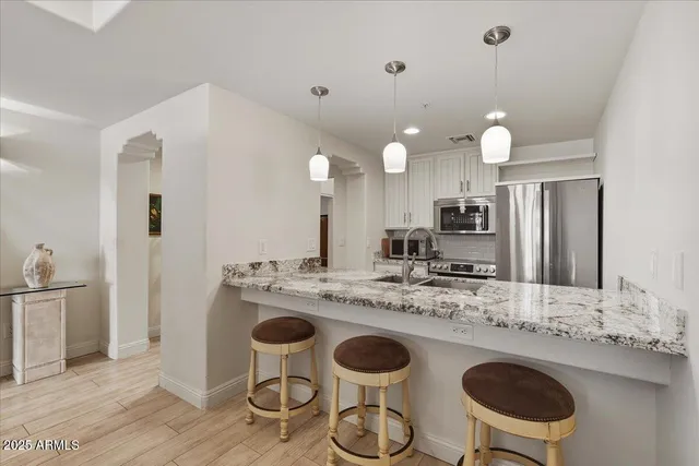 a kitchen with kitchen island granite countertop a sink and a stove