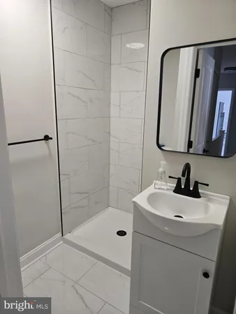 a bathroom with a sink a mirror and shower