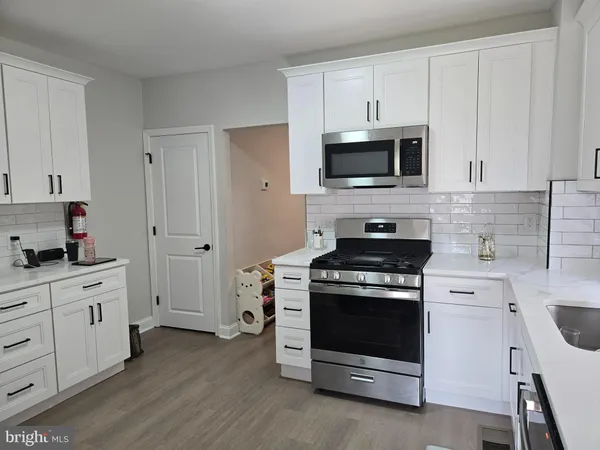 a kitchen with cabinets stainless steel appliances and wooden floor