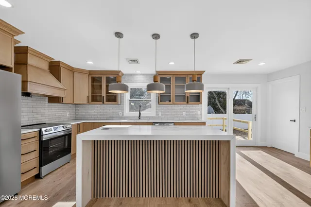a kitchen with stainless steel appliances granite countertop a sink and a stove