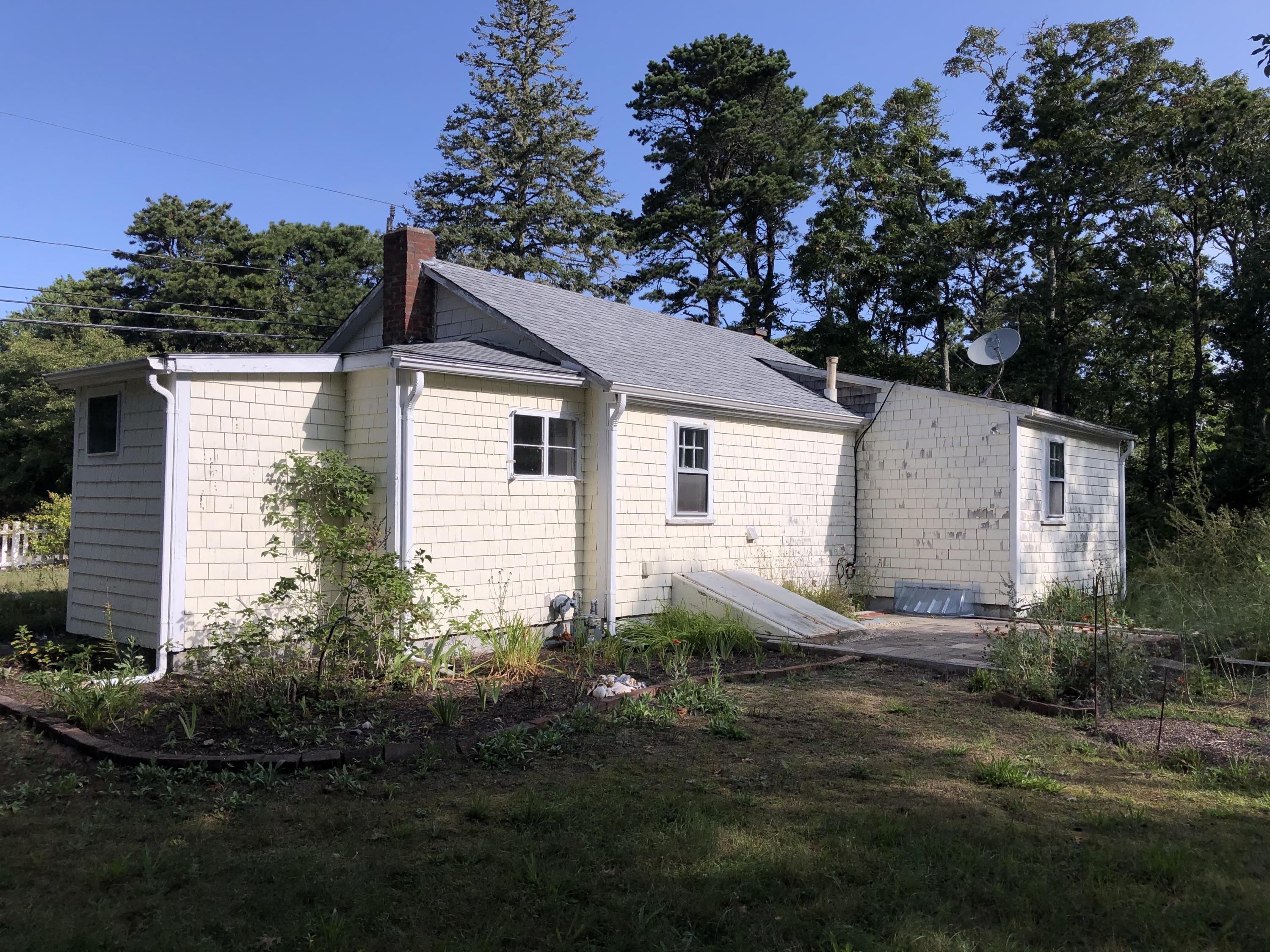 23 Kendrick Road Harwich, MA 02645 - Photo 2 of 13 a backyard of a house with plants and large tree