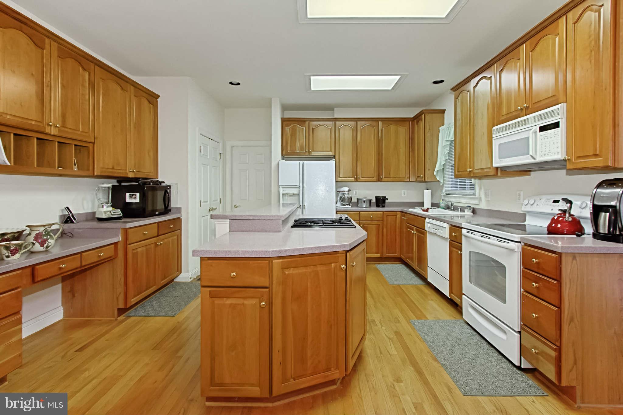 8635 Tuttle Road, Unit 2 Springfield, VA 22152 - Photo 11 of 30 a large kitchen with stainless steel appliances granite countertop a stove a sink dishwasher and a microwave oven with cabinets