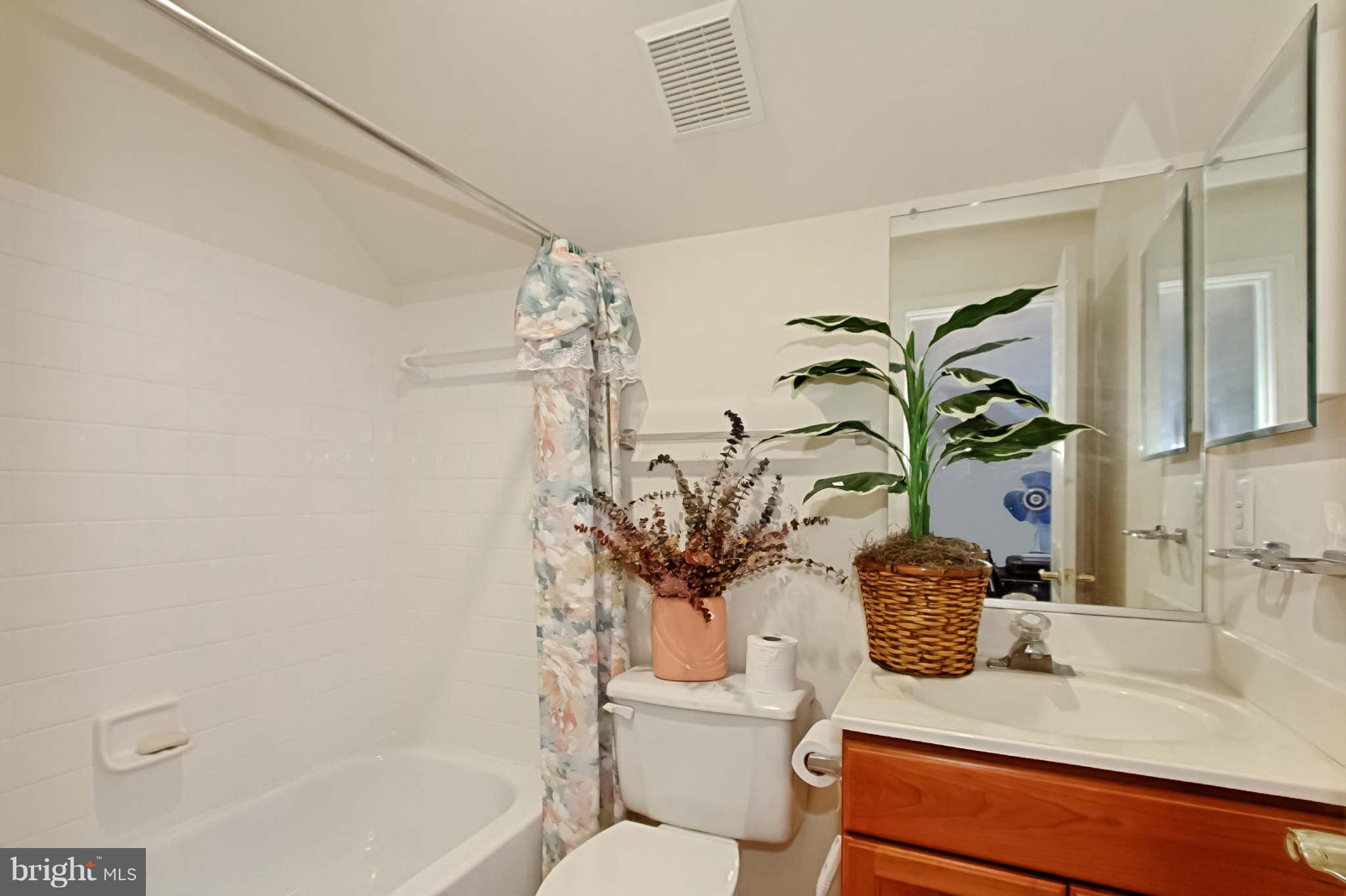8635 Tuttle Road, Unit 2 Springfield, VA 22152 - Photo 26 of 30 a bathroom with a granite countertop sink a toilet and shower