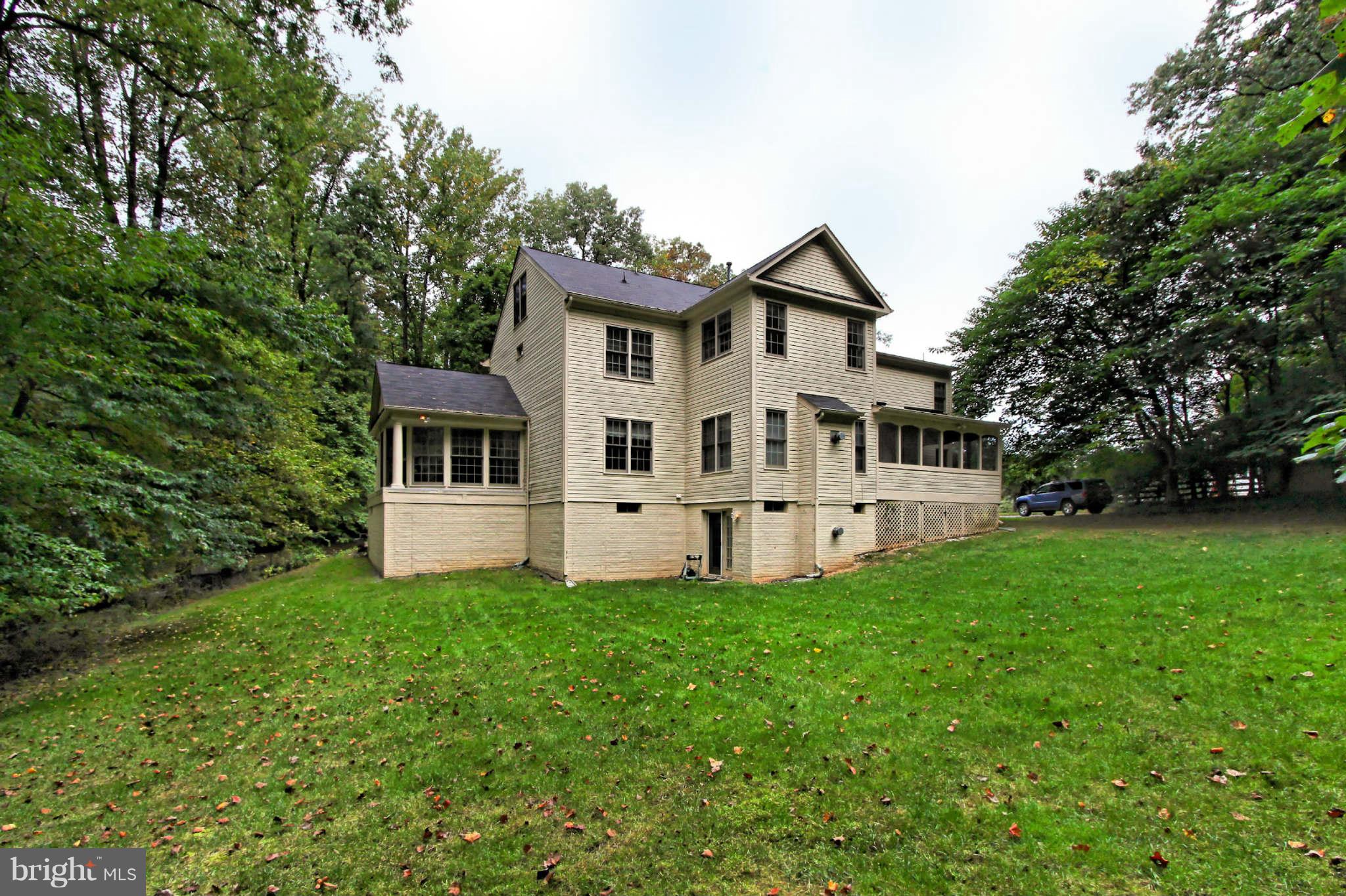 8635 Tuttle Road, Unit 2 Springfield, VA 22152 - Photo 28 of 30 a white house with a small yard and trees in the background