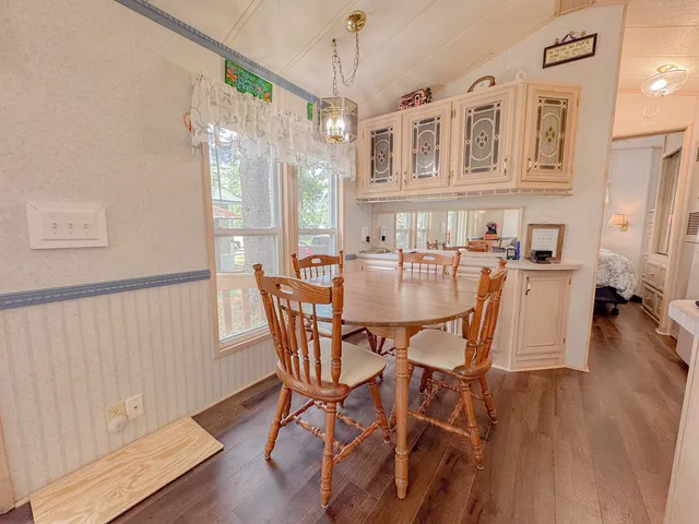 a dining room with furniture a chandelier and wooden floor