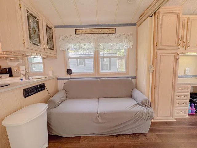 a living room with furniture a rug and a window