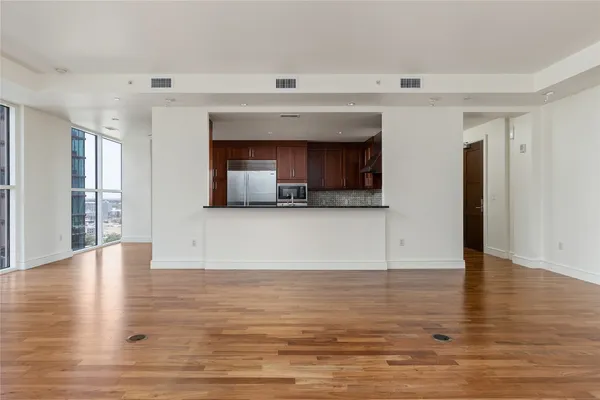 a view of empty room with wooden floor and fireplace