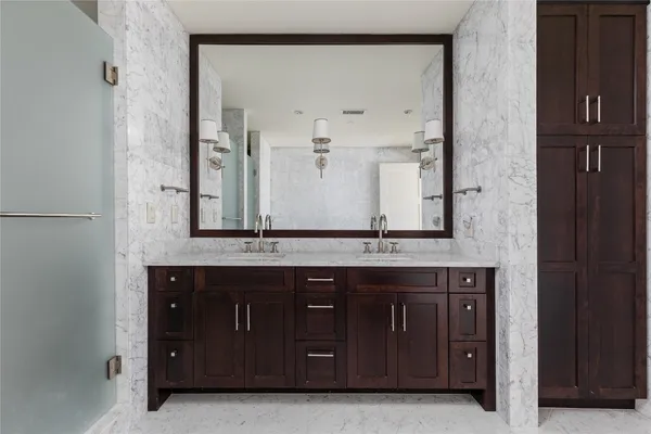 a modern kitchen with stainless steel appliances granite countertop a refrigerator a sink and wooden cabinets