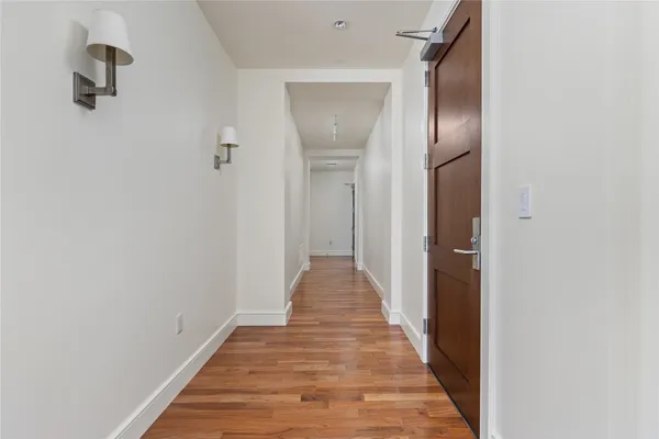 a view of a hallway with wooden floor
