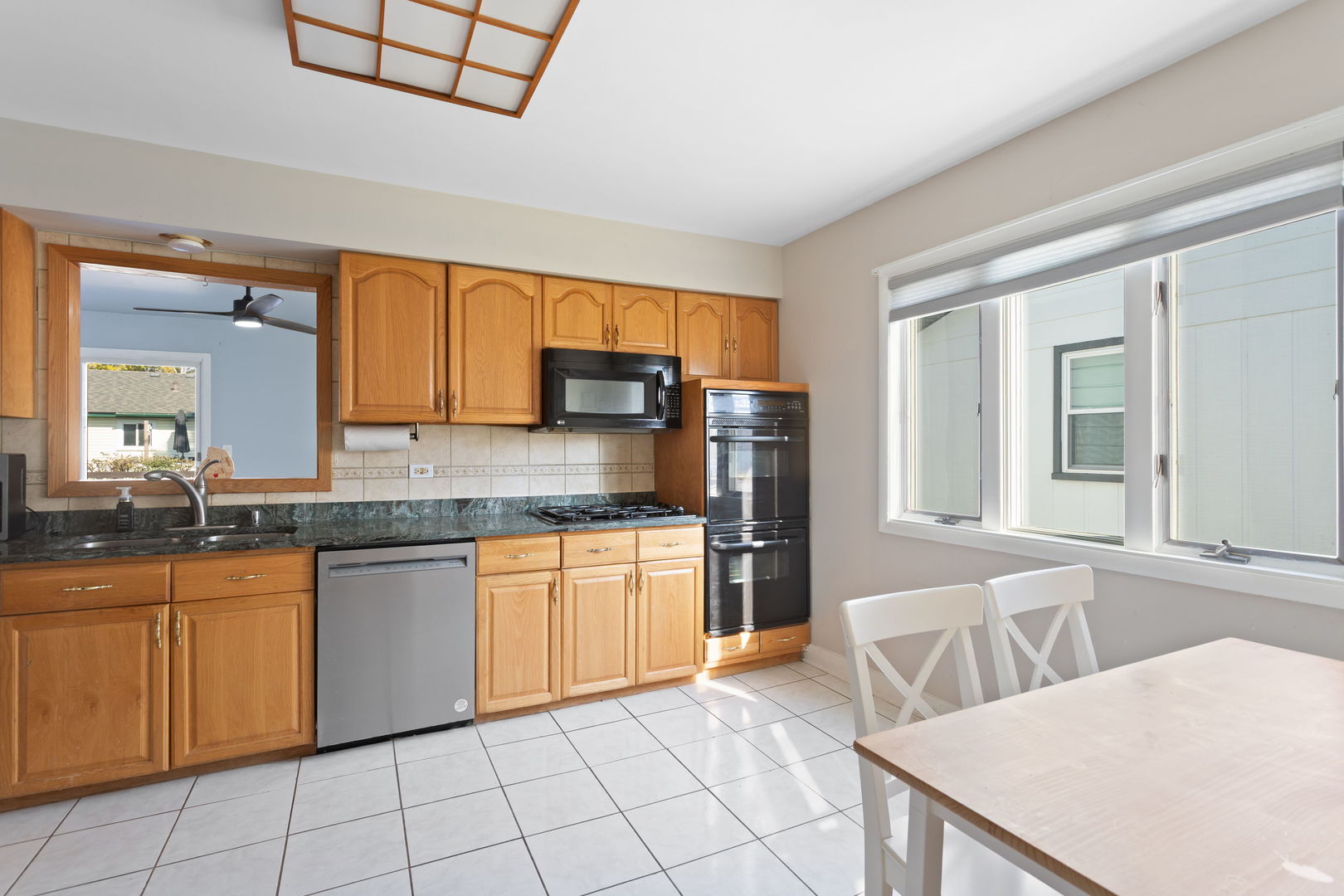1031 Conrad Court Elk Grove Village, IL 60007 - Photo 6 of 17 a kitchen with stainless steel appliances granite countertop a table chairs sink and cabinets