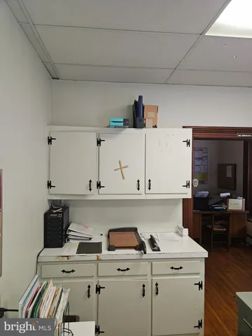a view of a hallway with wooden floor and a living room