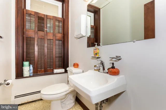 a bathroom with a sink toilet and a mirror