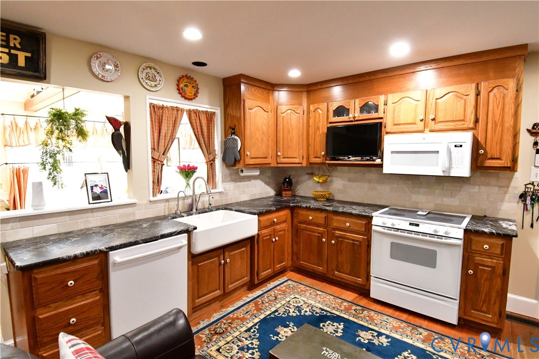 9101 Woodpecker Road Chesterfield, VA 23838 - Photo 17 of 50 a kitchen with stainless steel appliances granite countertop a sink stove and microwave