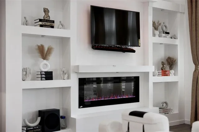 a living room with a fireplace and a flat screen tv