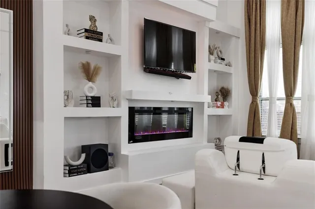 a living room with a fireplace and a flat screen tv