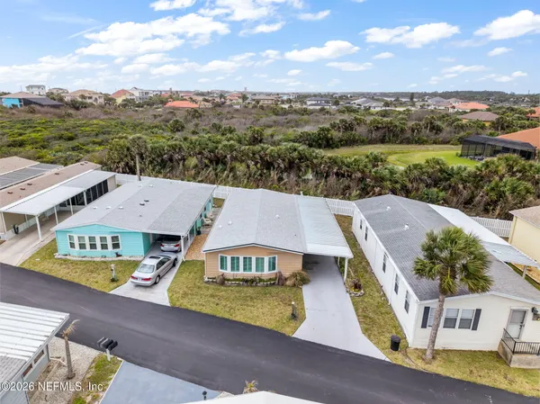 an aerial view of residential houses with outdoor space and trees