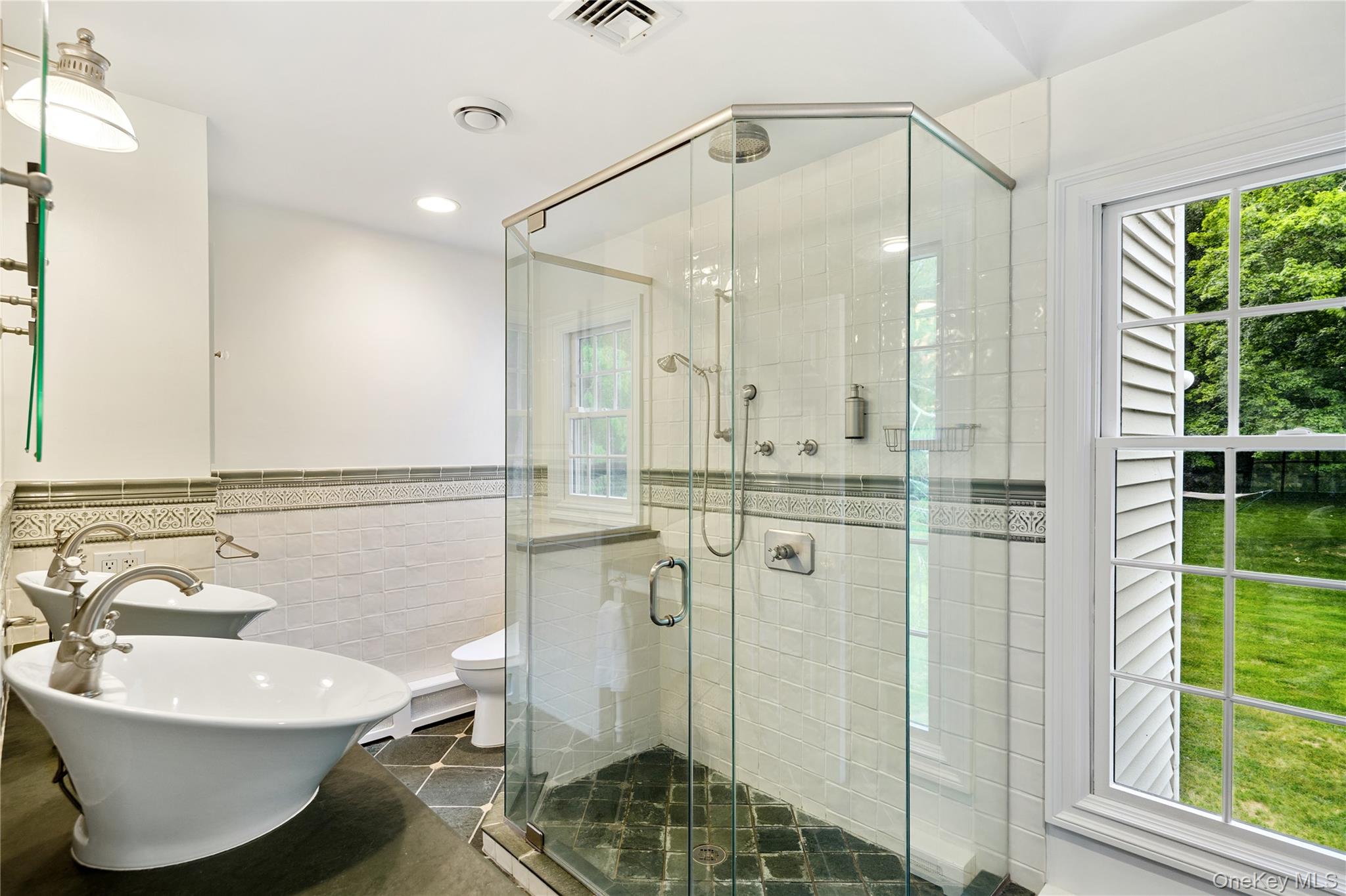 16 Fox Den Road Mount Kisco, NY 10549 - Photo 31 of 44 Primary bath with dual vessel sinks, Tot toilet, ceramic tile surround, slate floor, frameless glass shower enclosure