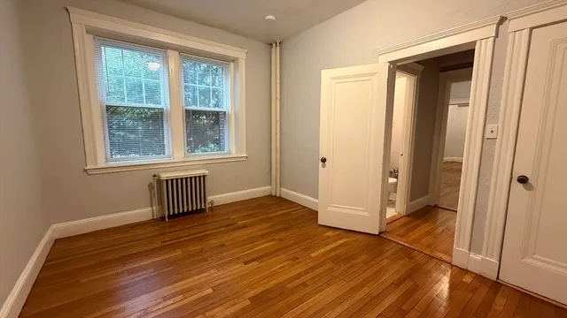 an empty room with wooden floor and a window