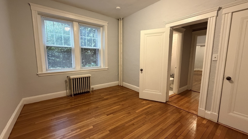 1945 Commonwealth Avenue, Unit 4 Boston, MA 02135 - Photo 15 of 22 an empty room with wooden floor and a window