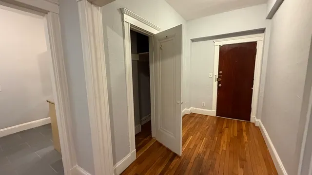 a view of a hallway with wooden floor and staircase